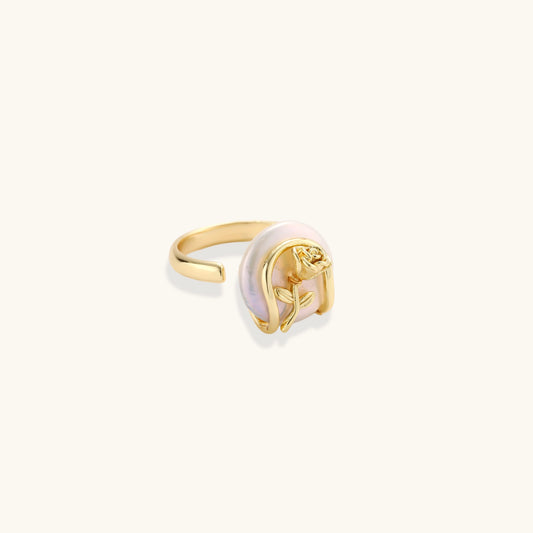 Gold-plated sculptural ring featuring a baroque pearl wrapped in a delicate rose and vine cage design
