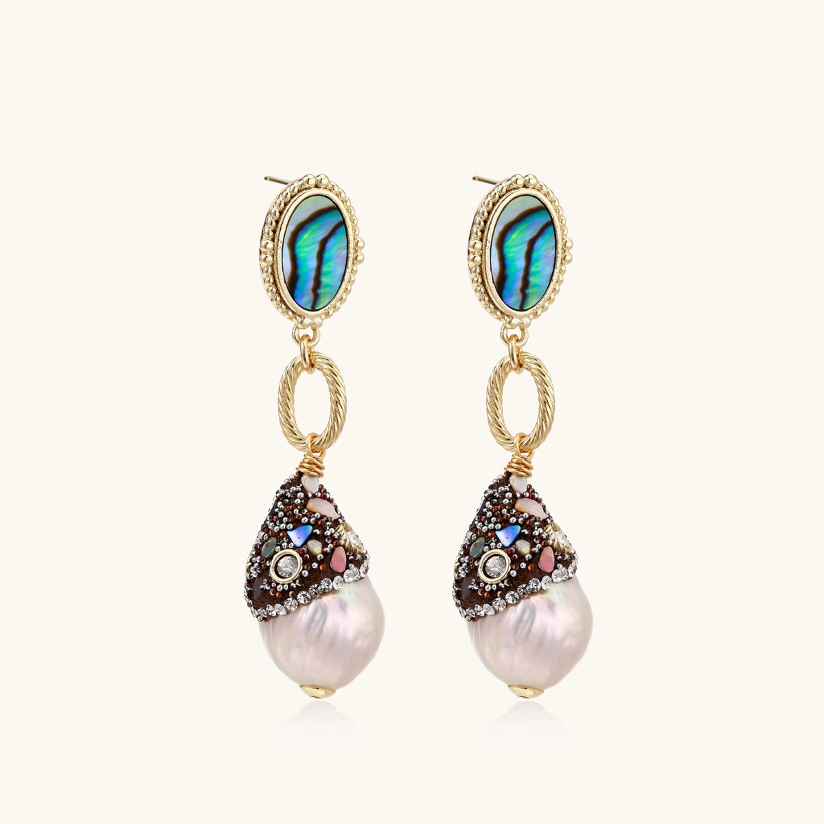 Gold drop earrings with iridescent abalone studs, rope links, jeweled caps and white baroque pearls on cream background