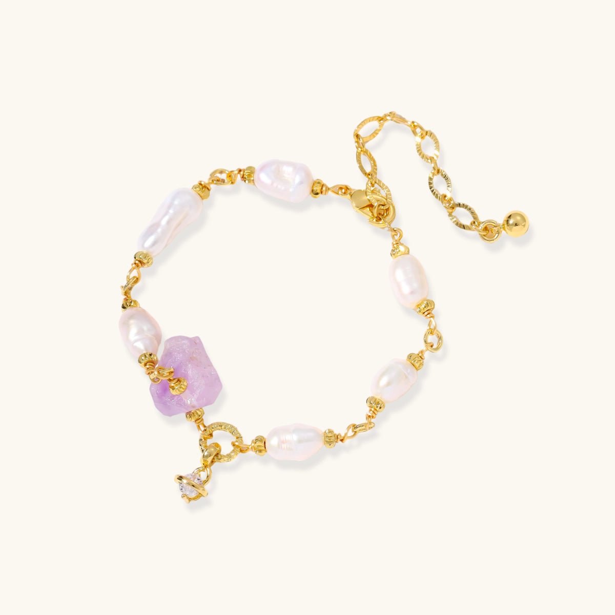 Gold-plated bracelet with lustrous baroque pearls and raw lavender amethyst centerpiece on white background.