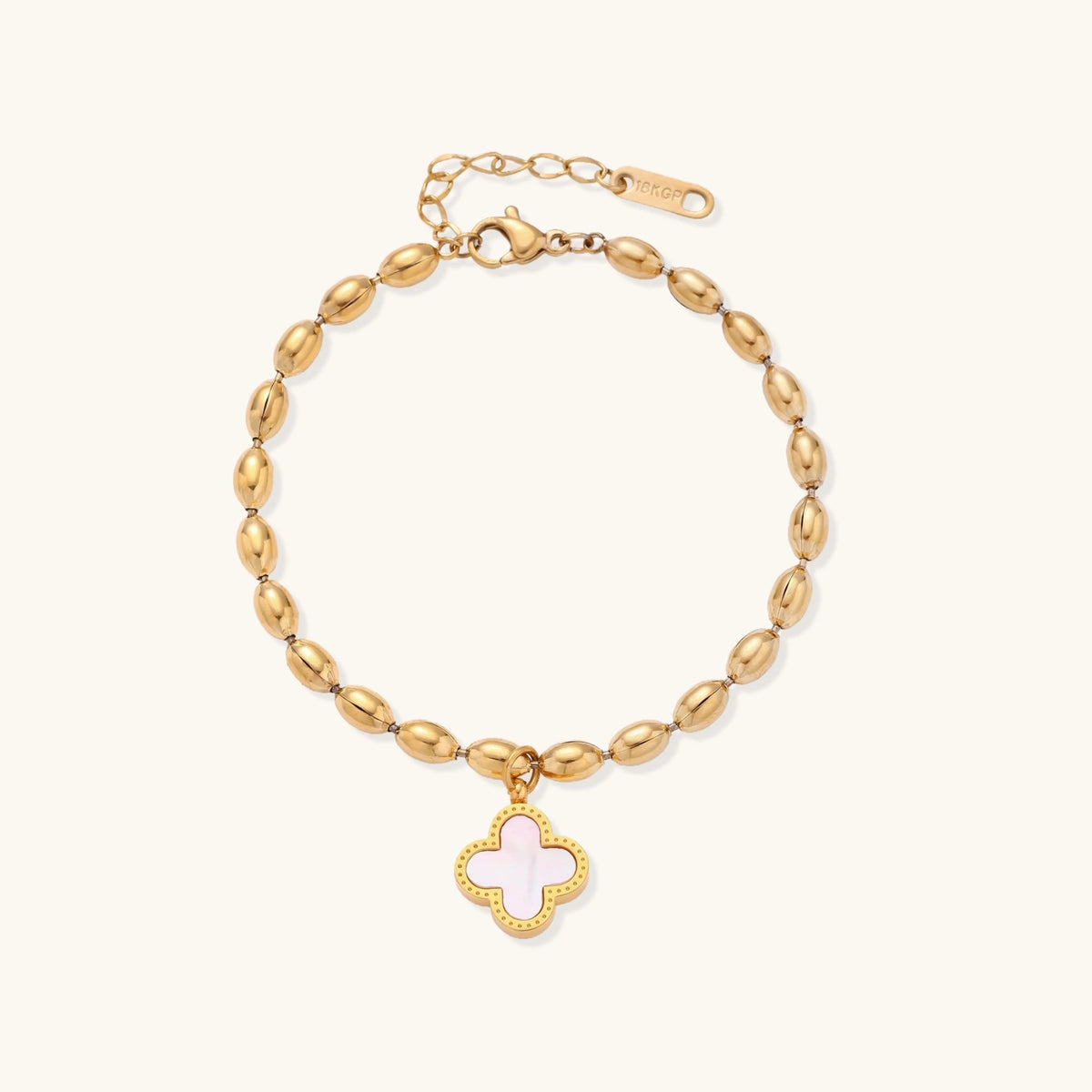 18K gold-plated oval bead chain bracelet with quatrefoil clover charm featuring mother of pearl inlay on cream background
