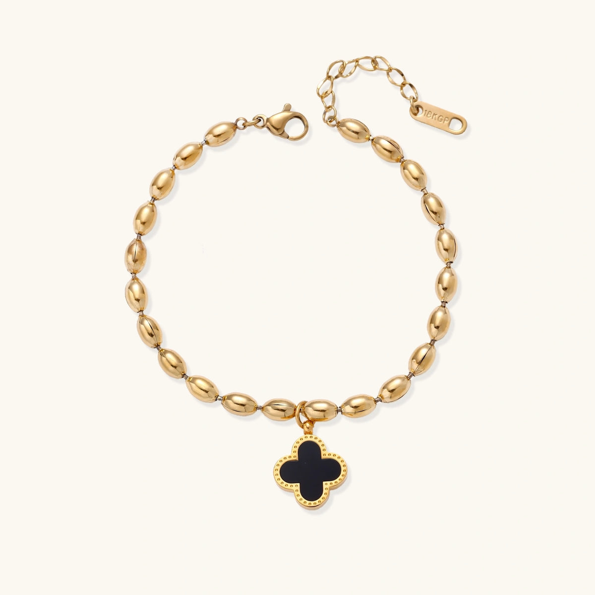 18K gold-plated oval bead chain bracelet with quatrefoil clover charm featuring mother of pearl inlay on cream background