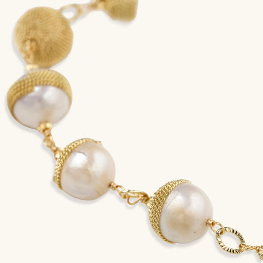 Adjustable bracelet with baroque pearls wrapped in delicate gold mesh netting connected by textured chain links